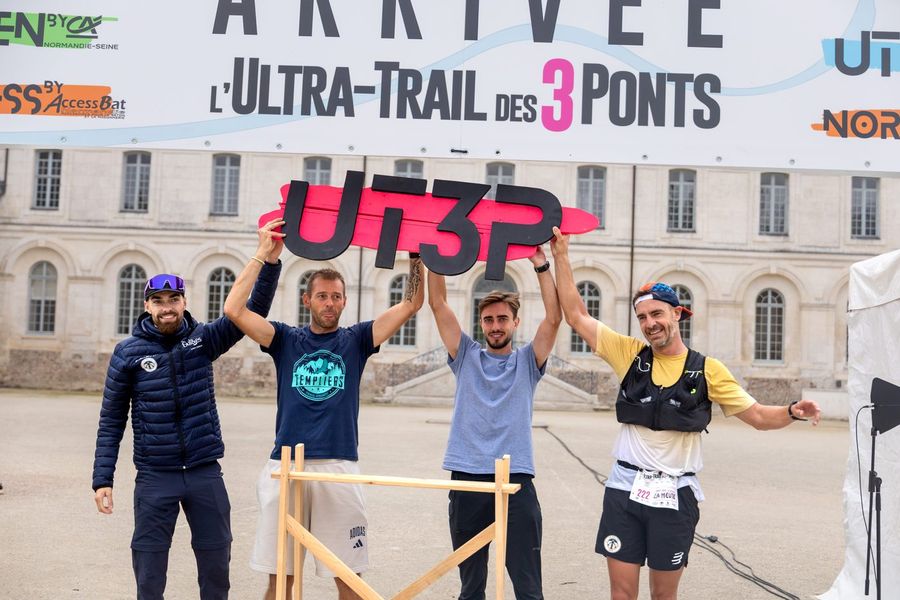 Les finishers de l'UT3P lèvent le panneau sous l'arche d'arrivée